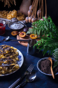 Low angle view of sweet pasta dessert, noodles with poppy seeds on dark background table.