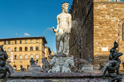 Low angle view of statue against historic building