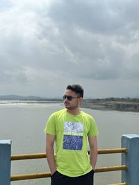 Portrait of young man standing against sea