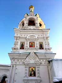 Low angle view of temple against building against clear sky