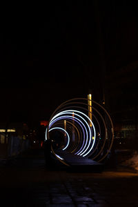 Light trails on street against sky at night