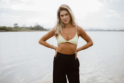 Portrait of young woman standing against sky