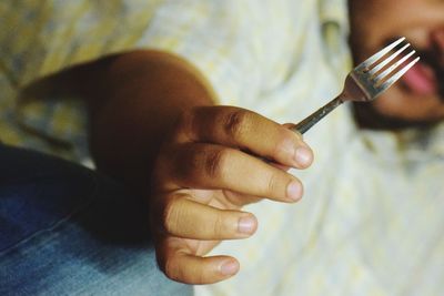 Midsection of man showing fork