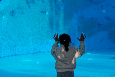 Rear view of woman standing in swimming pool