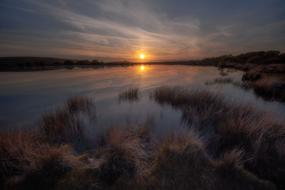 Scenic view of lake against sky during sunset