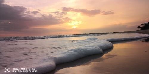 Scenic view of beach against sky during sunset