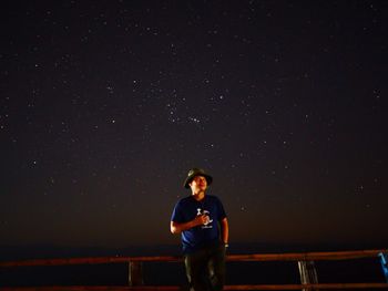 Full length of young man standing against sky at night