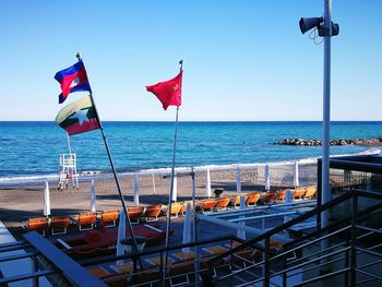 Flag on sea against clear sky