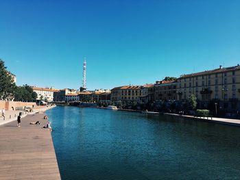 View of sea and buildings against blue sky