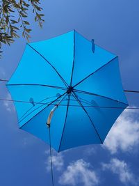 Low angle view of parasol against blue sky