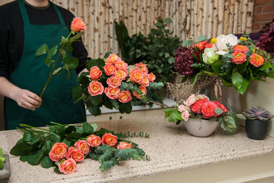 Red roses by flower pot on plant