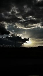 Silhouette of landscape against cloudy sky