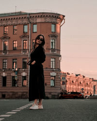 Rear view of woman standing against building