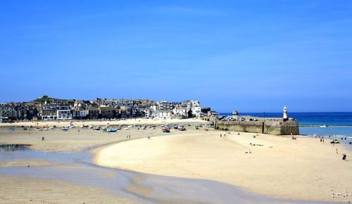 View of beach against clear blue sky