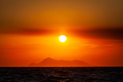 Scenic view of sea against romantic sky at sunset