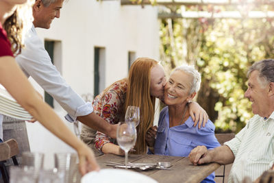 Happy family setting table outside for lunch