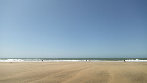 Scenic view of beach against clear blue sky