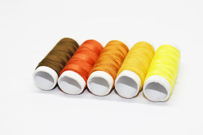 Colored thread coils on white background, sewing