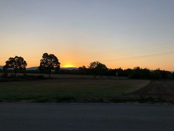 Scenic view of field against clear sky during sunset