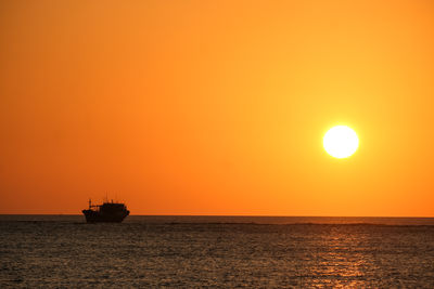 Scenic view of sea against orange sky