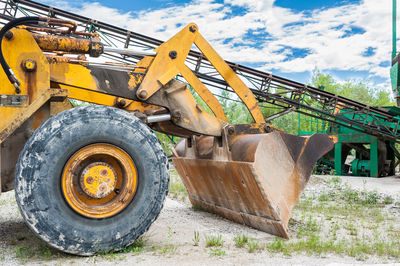 Earth mover at construction site against sky