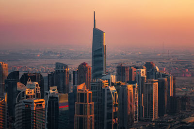 High angle view of modern buildings in city during sunset