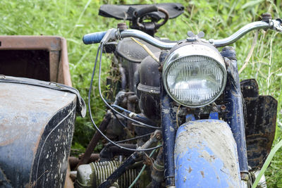 Close-up of abandoned motorcycle on field