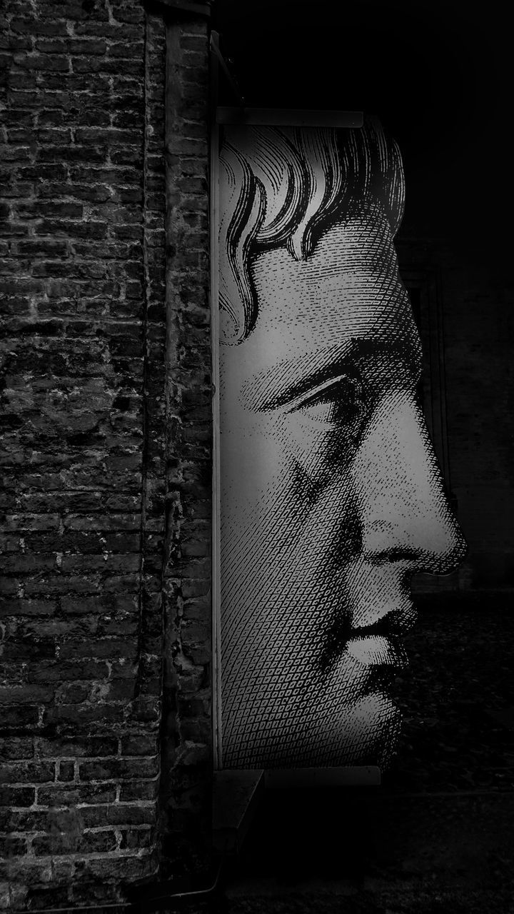 PORTRAIT OF YOUNG WOMAN LOOKING AWAY AGAINST WALL