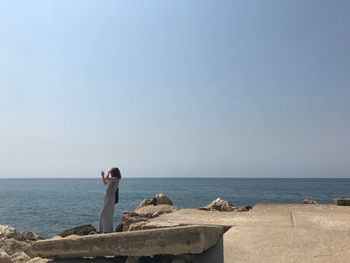 Man standing by sea against clear sky