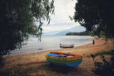 Boats moored on shore against sky