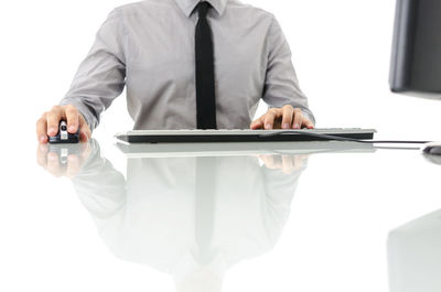 Midsection of man using laptop on table