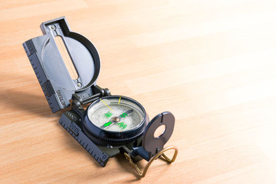 Close-up of compass on wooden table