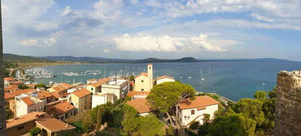 High angle view of townscape by sea against sky