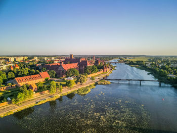 River amidst buildings in city against clear sky