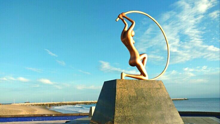 WOMAN JUMPING AT SWIMMING POOL AGAINST SKY