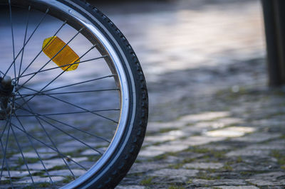 Cropped image of bicycle on cobblestone street