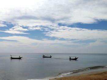 Boats moored on sea against sky