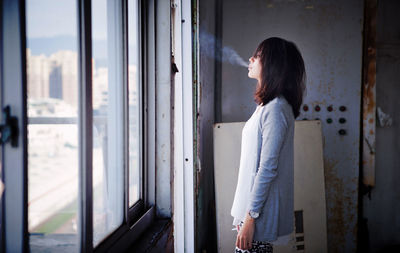 Young woman smoking in building