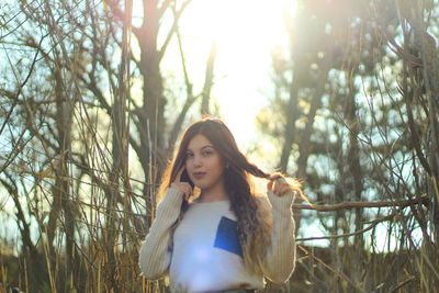 Portrait of young woman standing at forest