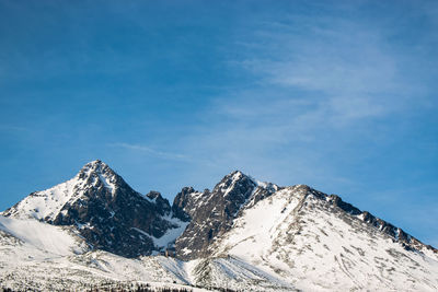 Scenic view of snowcapped mountains against blue sky