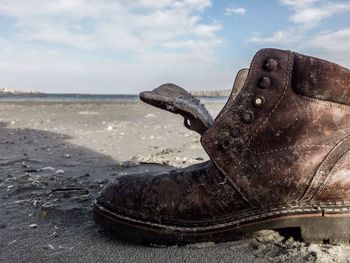 Close-up of abandoned shoe on beach