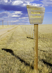 Pawnee national grassland road sign on wooden post in field