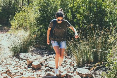 Full length of young woman standing on rock