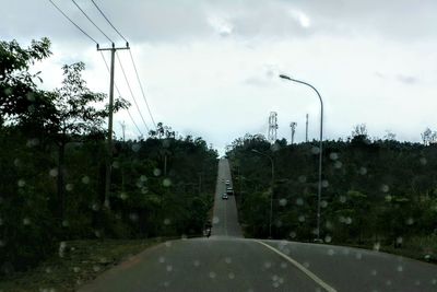 Road amidst trees against sky