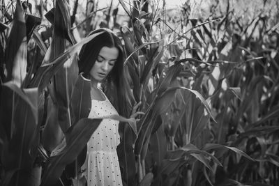 Portrait of woman standing by plants