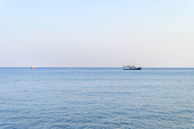 Sailboat sailing on sea against clear sky