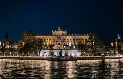 Illuminated facade of parliament house against sky at night