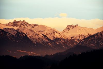 Scenic view of snowcapped mountains against sky during sunset