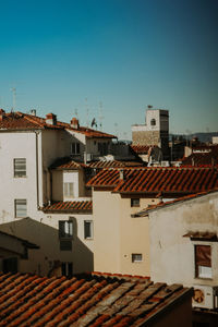 Houses in town against clear blue sky