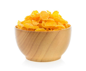 Close-up of orange slices in bowl against white background